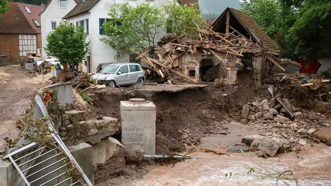 Blick auf ein durch Hochwasser zerstörtes Gebäude an der Wieslauf. - Bild: Marijan Murat/dpa