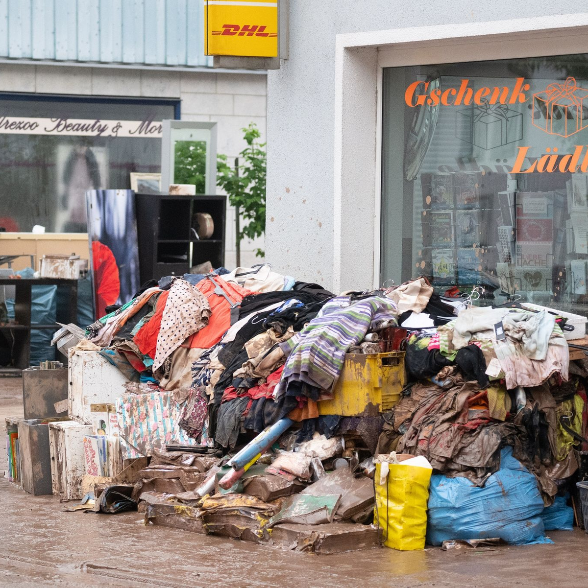 Vom Hochwasser zerstörter Hausrat vor einem Einzelhandelsgeschäft in Rudersberg. - Foto: Marijan Murat/dpa
