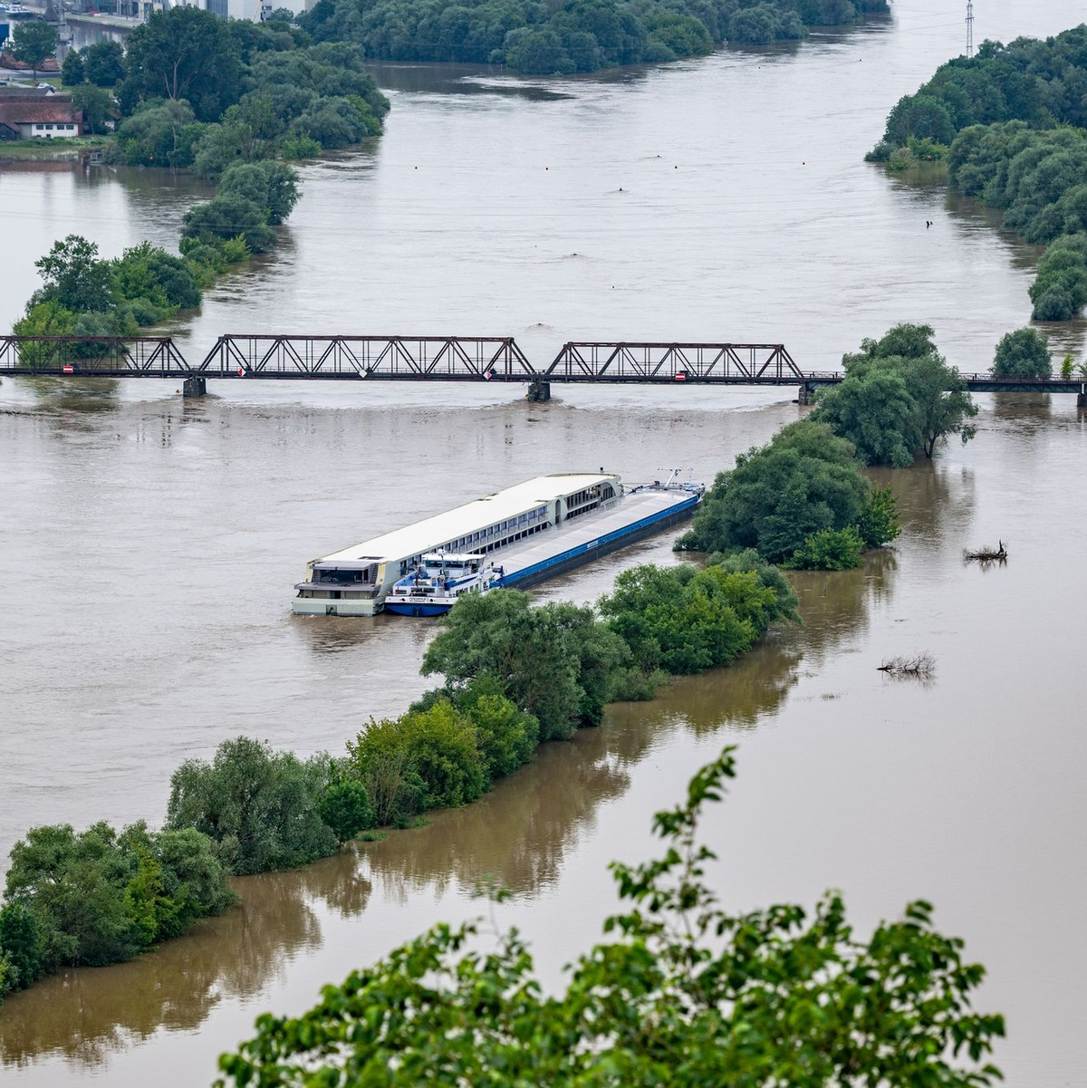 Zwei Schiffe liegen im Hochwasser der Donau. - Foto: Armin Weigel/dpa