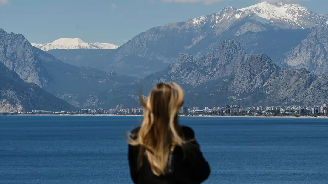 Die Aussicht genießen: Die Aussichtsplattform des Alten Hafens von Antalya mit Blick auf die schneebedeckten Berggipfel. - Bild: Marijan Murat/dpa