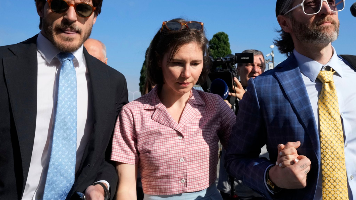 Amanda Knox (m.) mit ihrem Ehemann Christopher Robinson (r) in Florenz. - Foto: Antonio Calanni/AP