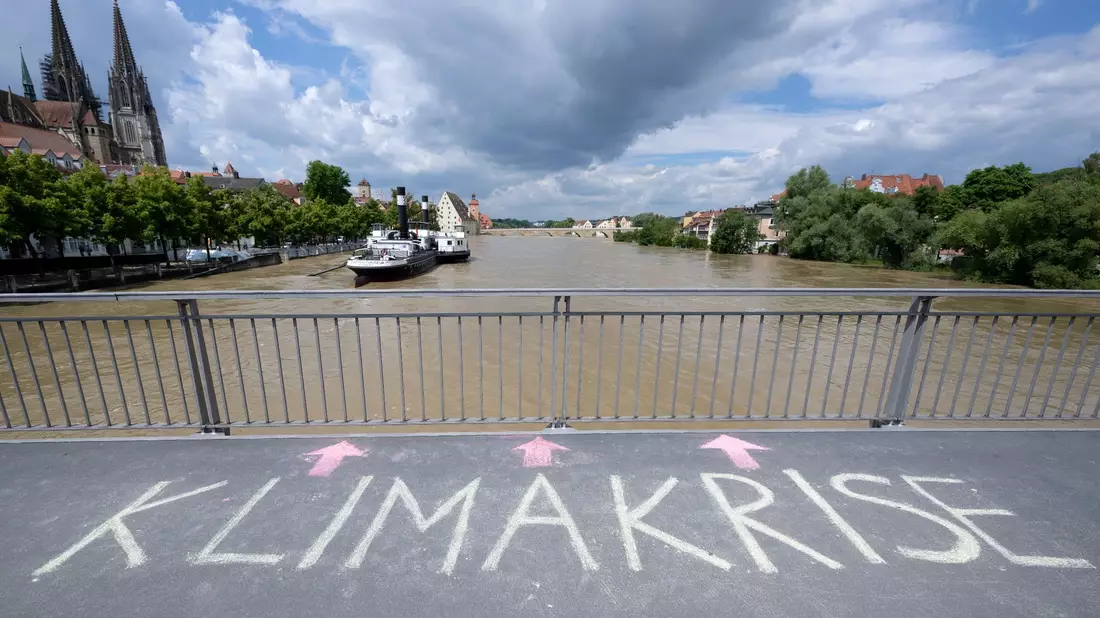Jemand hat in Regensburg das Wort «Klimakrise» auf eine Brücke über der Donau geschrieben. - Bild: Sven Hoppe/dpa