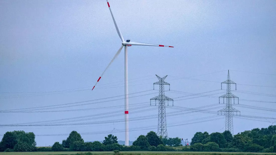 Eine Windkraftanlage und Hochspannungsleitungen in NRW. - Bild: Thomas Banneyer/dpa