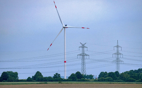 Eine Windkraftanlage und Hochspannungsleitungen in NRW. - Foto: Thomas Banneyer/dpa