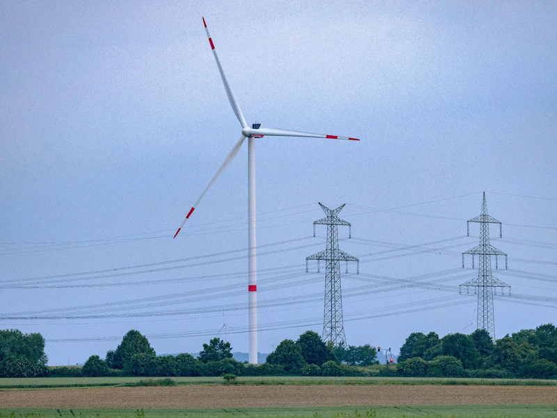 Eine Windkraftanlage und Hochspannungsleitungen in NRW. - Foto: Thomas Banneyer/dpa
