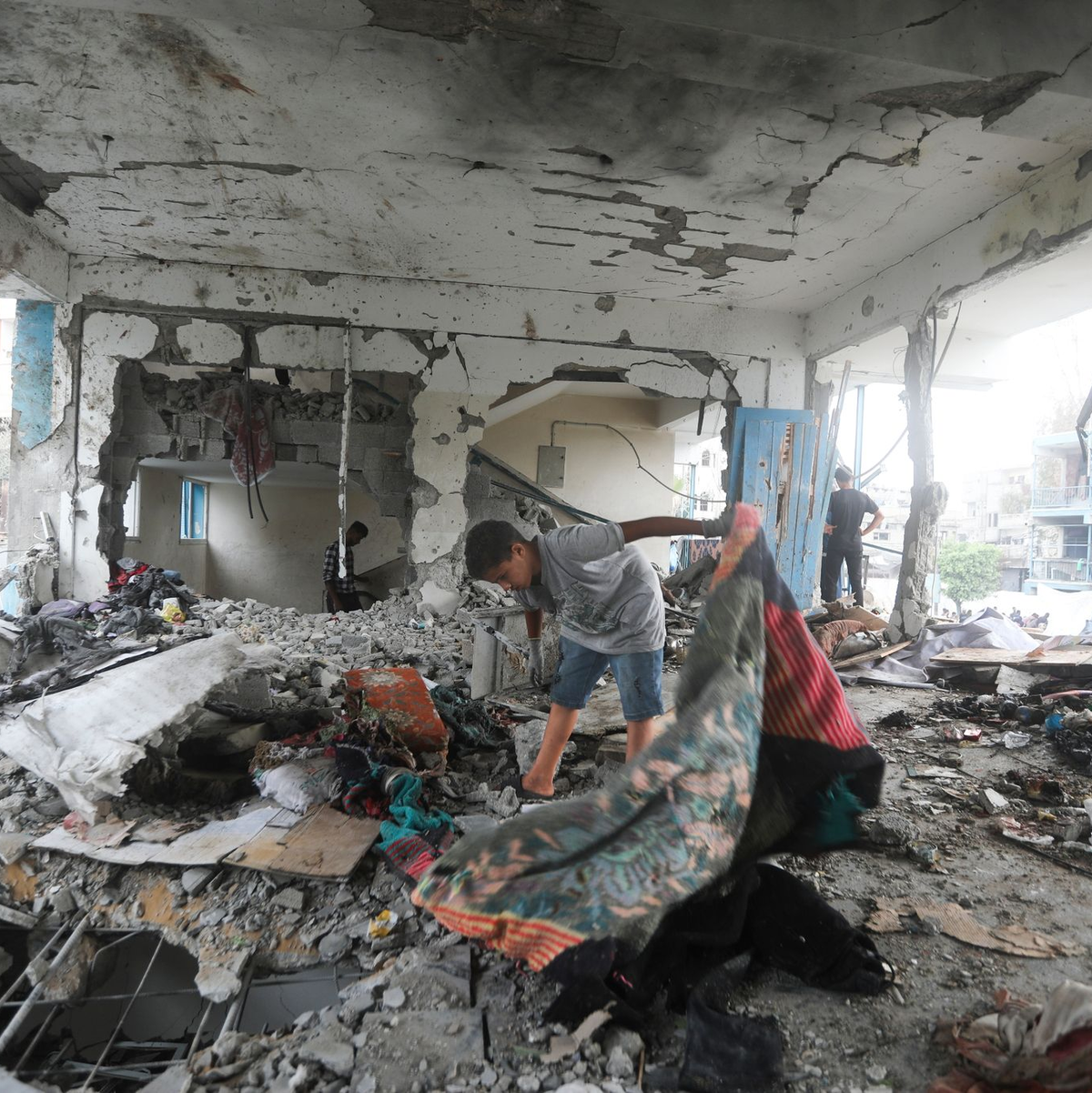 Palästinenser nehmen in einer vom UN-Palästinenserhilfswerk UNRWA betriebenen Schule die Folgen des israelischen Angriffs  in Augenschein. - Foto: Abdel Kareem Hana/AP/dpa