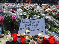 Blumen und Kerzen auf dem Marktplatz in Mannheim zum Gedenken an den getöteten Polizisten. - Foto: Bernd Weißbrod/dpa