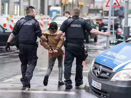 Polizisten haben einer Frau bei ihrer Festnahme Handschellen angelegt, nachdem diese sich mit einer anderen Frau auf offener Straße im Bahnhofsviertel geprügelt hatte. - Foto: Boris Roessler/dpa
