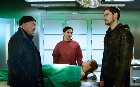 Jan Marxen (Frédéric Brossier, r.) erzählt Dr. Gabriele Simkeit (Eva Sixt, 2.v.l.) und Otto Garber (Florian Martens, l.) von der Medikamentenabhängigkeit seiner toten Freundin. - Foto: Katrin Knoke/ZDF/dpa