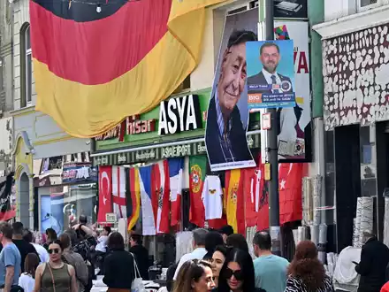 Bundespräsident Frank-Walter Steinmeier (M) zusammen mit Hasan Yildirim (l) und Özcan Yildirim vor ihrem Friseurgeschäft. Am 9. Juni 2024 hatten die NSU-Terroristen Mundlos und Böhnhardt in der Kölner Keupstraße vor dem Friseurgeschäft eine Nagelbombe gezündet. - Foto: Henning Kaiser/dpa