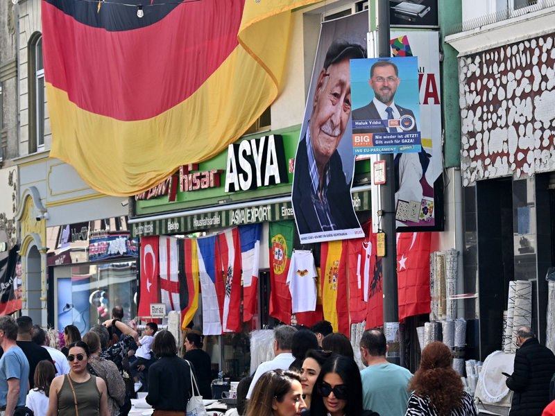 Bundespräsident Frank-Walter Steinmeier (M) zusammen mit Hasan Yildirim (l) und Özcan Yildirim vor ihrem Friseurgeschäft. Am 9. Juni 2024 hatten die NSU-Terroristen Mundlos und Böhnhardt in der Kölner Keupstraße vor dem Friseurgeschäft eine Nagelbombe gezündet. - Foto: Henning Kaiser/dpa