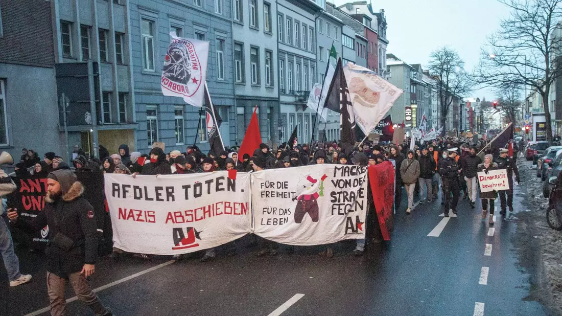 Teilnehmer einer Demonstration mit einem Plakat und der Aufschrift «AfDler töten. Nazis abschieben!». - Bild: Ralf Roeger/dpa
