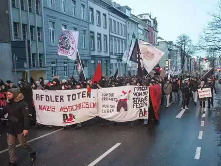 Teilnehmer einer Demonstration mit einem Plakat und der Aufschrift «AfDler töten. Nazis abschieben!». - Foto: Ralf Roeger/dpa