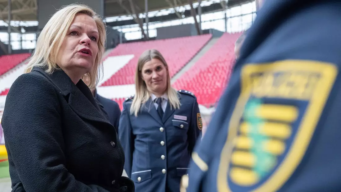 Nancy Faeser (SPD, l), Bundesinnenministerin, unterhält sich in der Leipziger Arena mit Vertretern der Polizei. - Bild: Hendrik Schmidt/dpa