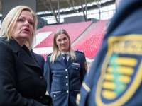 Nancy Faeser (SPD, l), Bundesinnenministerin, unterhält sich in der Leipziger Arena mit Vertretern der Polizei. - Foto: Hendrik Schmidt/dpa
