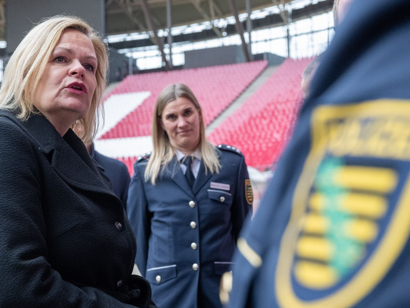Nancy Faeser (SPD, l), Bundesinnenministerin, unterhält sich in der Leipziger Arena mit Vertretern der Polizei. - Foto: Hendrik Schmidt/dpa
