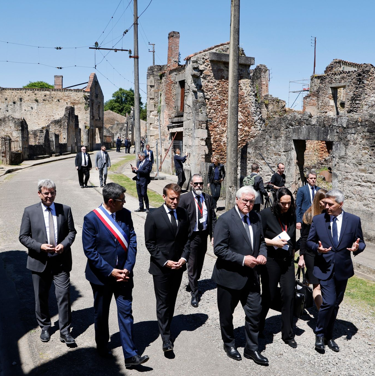 Der französische Präsident Emmanuel Macron und der deutsche Bundespräsident Frank-Walter Steinmeier gehen an Ruinen in Oradour-sur-Glane vorbei. - Foto: Ludovic Marin/AFP Pool/AP/dpa