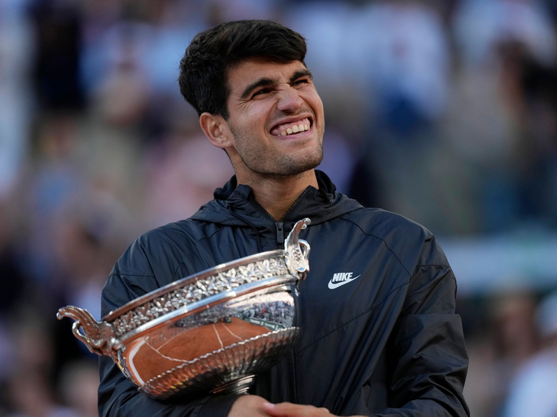 Carlos Alcaraz feiert mit der Trophäe nach seinem Sieg. - Foto: Thibault Camus/AP
