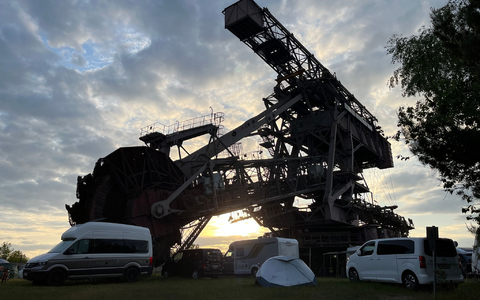 Wohnwagen und Wohnmobile vor einem Schaufelradbagger in Ferropolis in Sachsen-Anhalt (Archivbild von 2023). - Foto: Jan Woitas/dpa