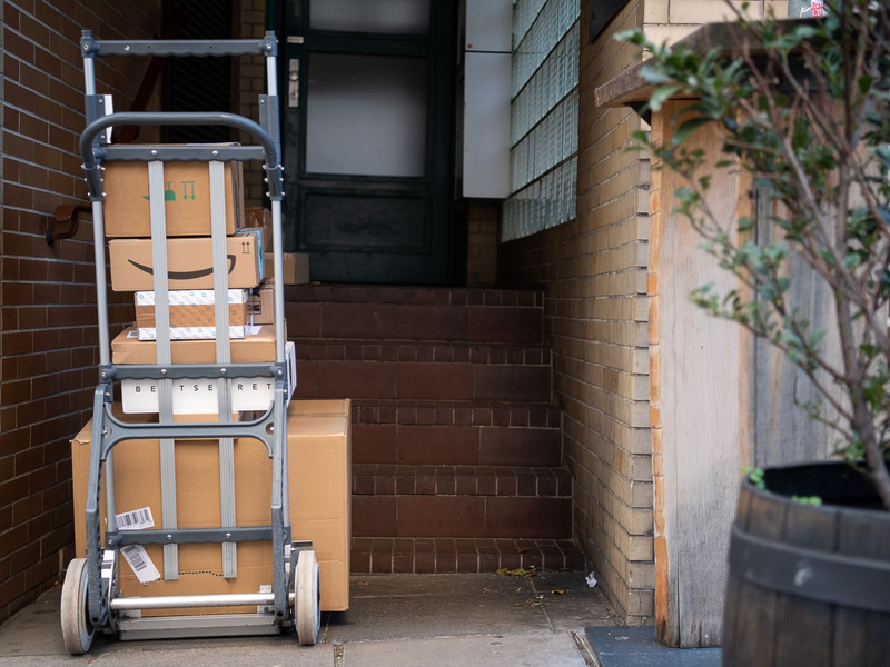 Gestapelte Pakete in einem Hauseingang. Das Postgesetz ist in seinen wesentlichen Teilen schon seit 1998 gültig. - Foto: Sebastian Gollnow/dpa