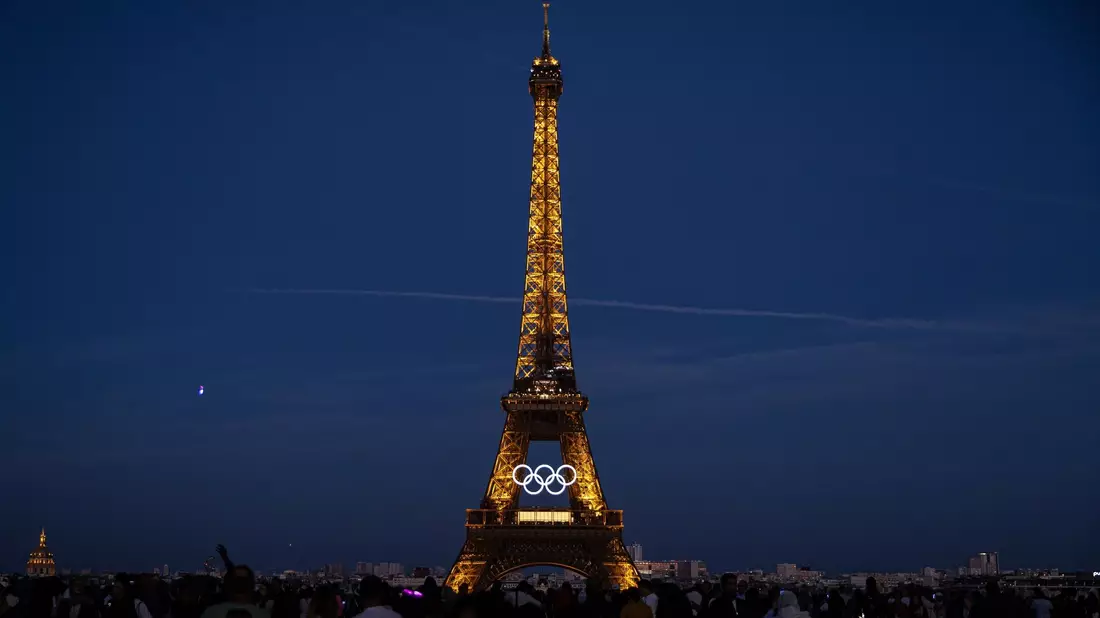Die olympischen Ringe sind auf dem Eiffelturm in Paris zu sehen. - Bild: Aurelien Morissard/AP/dpa