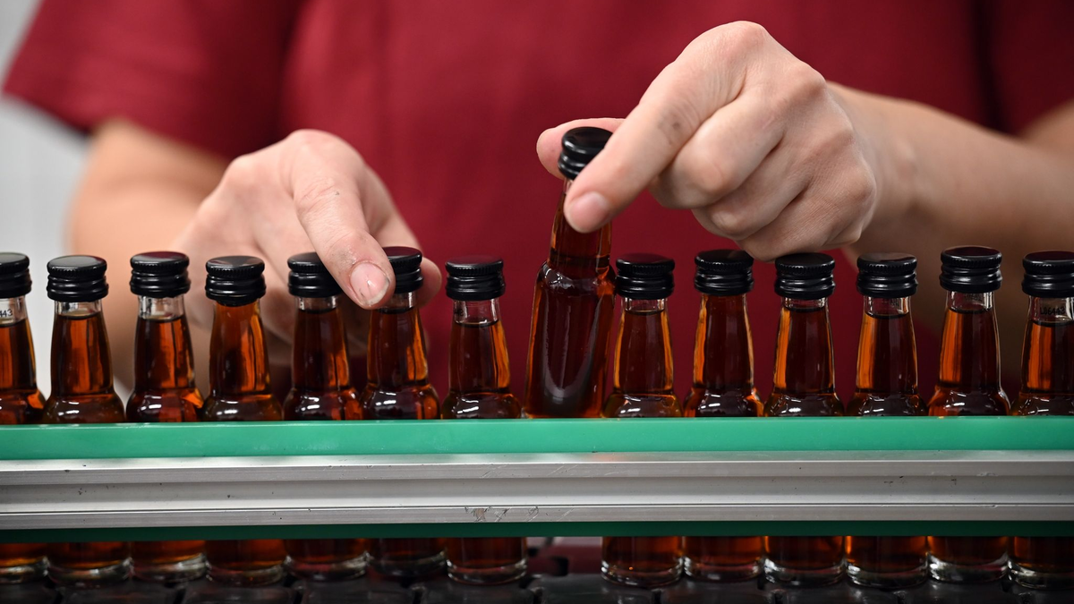 Eine Mitarbeiterin eines Spirituosenherstellers kontrolliert die abgefüllten Flaschen. Die Zurückhaltung beim Konsum macht sich auch bei den Spirituosen-Herstellern bemerkbar (Symbolbild). - Foto: Patricia Bartos/dpa