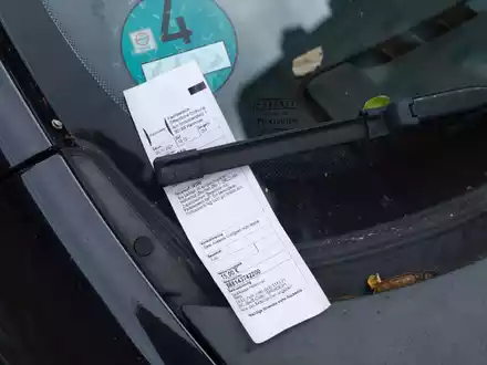 Ein Strafzettel klemmt hinter einem Scheibenwischer (Symbolbild). Das Bundesverfassungsgericht hat betont, dass der Halter eines Autos nicht automatisch der Täter ist, wenn mit dem Wagen Parkverstöße begangen werden. - Foto: Ole Spata/dpa