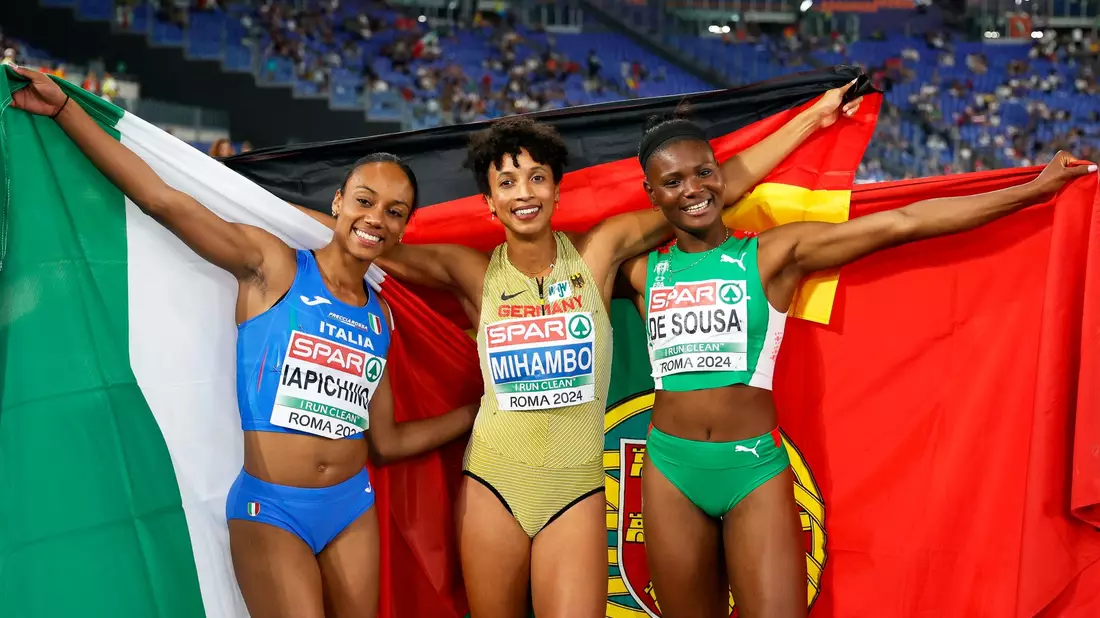 Malaika Mihambo (M) jubelt nach ihrem EM-Sieg im Weitsprung. - Bild: Riccardo de Luca/AP