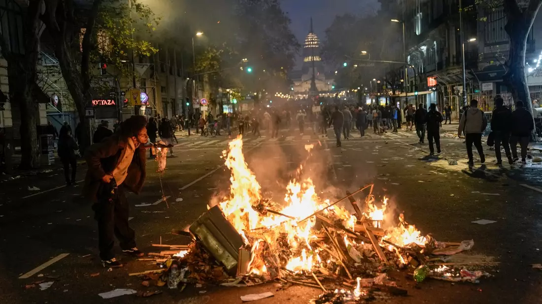 Ein brennender Müllhaufen als Zigarettenanzünder. Regierungskritische Demonstranten versammelten sich vor dem Kongress in Buenos Aires. - Bild: Rodrigo Abd/AP