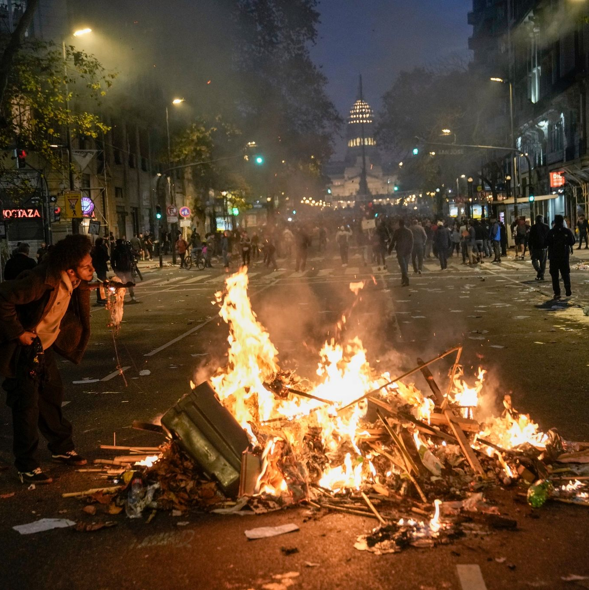 Ein brennender Müllhaufen als Zigarettenanzünder. Regierungskritische Demonstranten versammelten sich vor dem Kongress in Buenos Aires. - Foto: Rodrigo Abd/AP