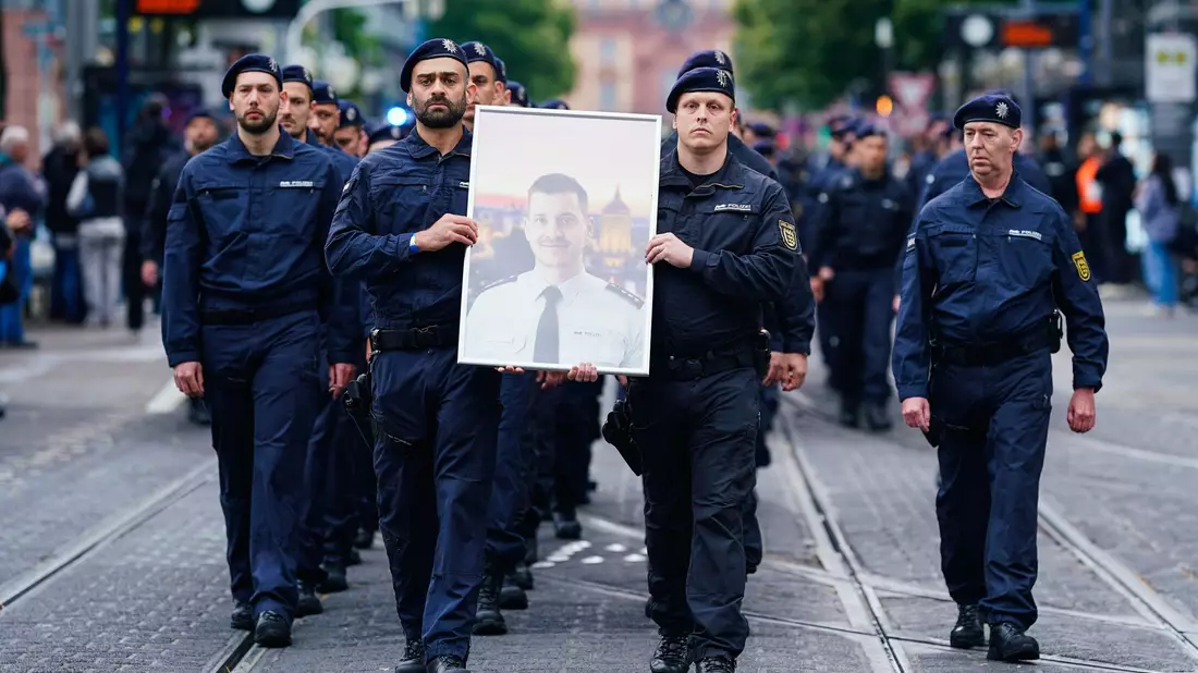 In Gedenken an ihren tödlich verletzten Kollegen Rouven Laur ziehen Polizisten durch die Mannheimer Innenstadt. - Bild: Uwe Anspach/dpa