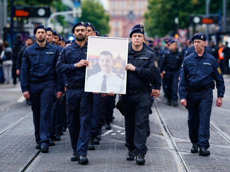 In Gedenken an ihren tödlich verletzten Kollegen Rouven Laur ziehen Polizisten durch die Mannheimer Innenstadt. - Foto: Uwe Anspach/dpa