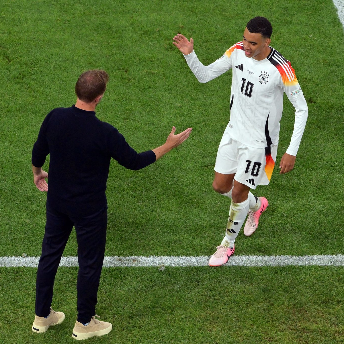 Bundestrainer Julian Nagelsmann beglückwünscht Jamal Musiala zum tollen Spiel. - Foto: Peter Kneffel/dpa