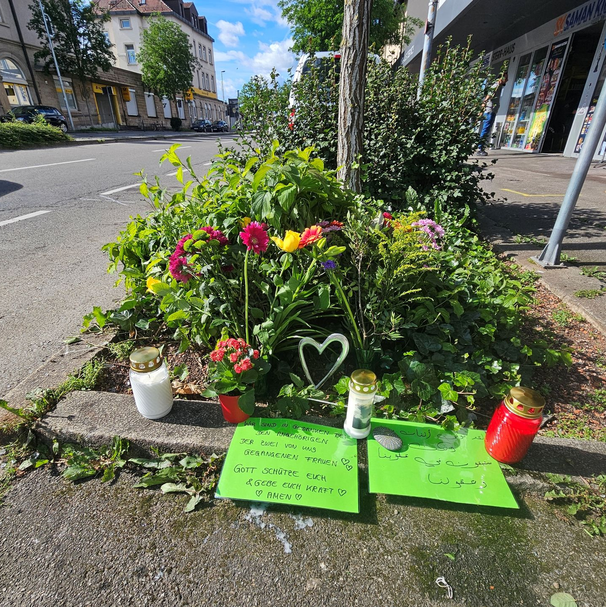 Blumen und Grablichter sind an der Unfallstelle aufgestellt worden. - Foto: Andreas Rosar/dpa