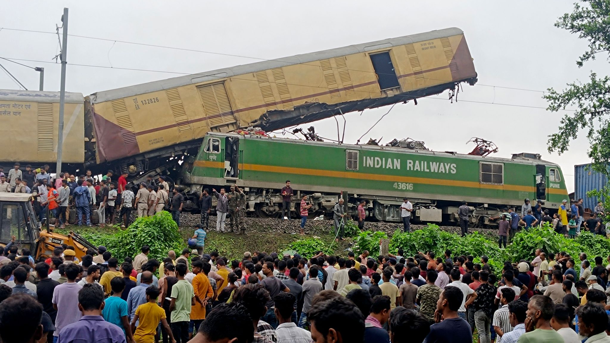 Schaulustige beobachten die Arbeit von Rettungskräften, nachdem ein Güterzug in der Nähe des Bahnhofs von New Jalpaiguri im indischen Bundesstaat Westbengalen einen Personenzug gerammt hat. - Foto: Diptendu Dutta/AP/dpa