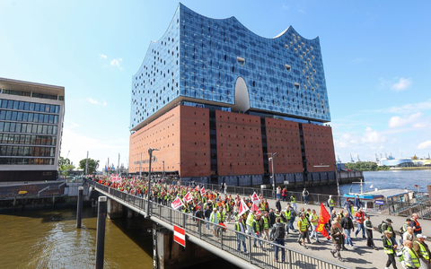 Streikende Hafenarbeiter ziehen bei einer Demonstration an der Hamburger Elbphilharmonie entlang. - Foto: Bodo Marks/dpa