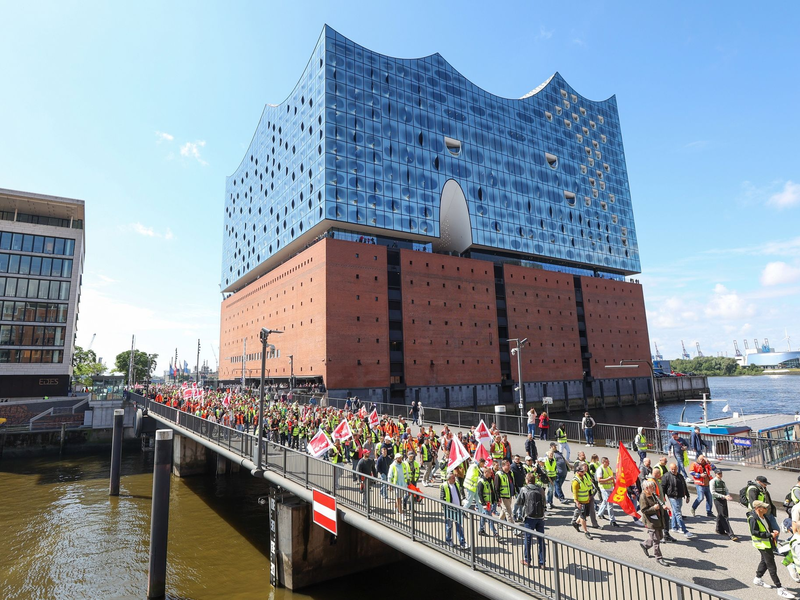 Streikende Hafenarbeiter ziehen bei einer Demonstration an der Hamburger Elbphilharmonie entlang. - Foto: Bodo Marks/dpa
