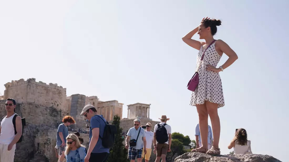Touristen auf dem Aeropagous-Hügel vor der antiken Akropolis im Zentrum Athens. - Bild: Petros Giannakouris/AP
