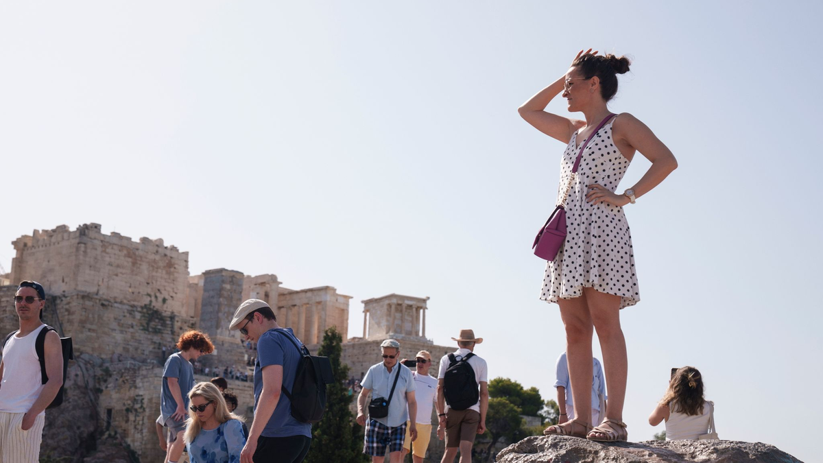 Touristen auf dem Aeropagous-Hügel vor der antiken Akropolis im Zentrum Athens. - Foto: Petros Giannakouris/AP