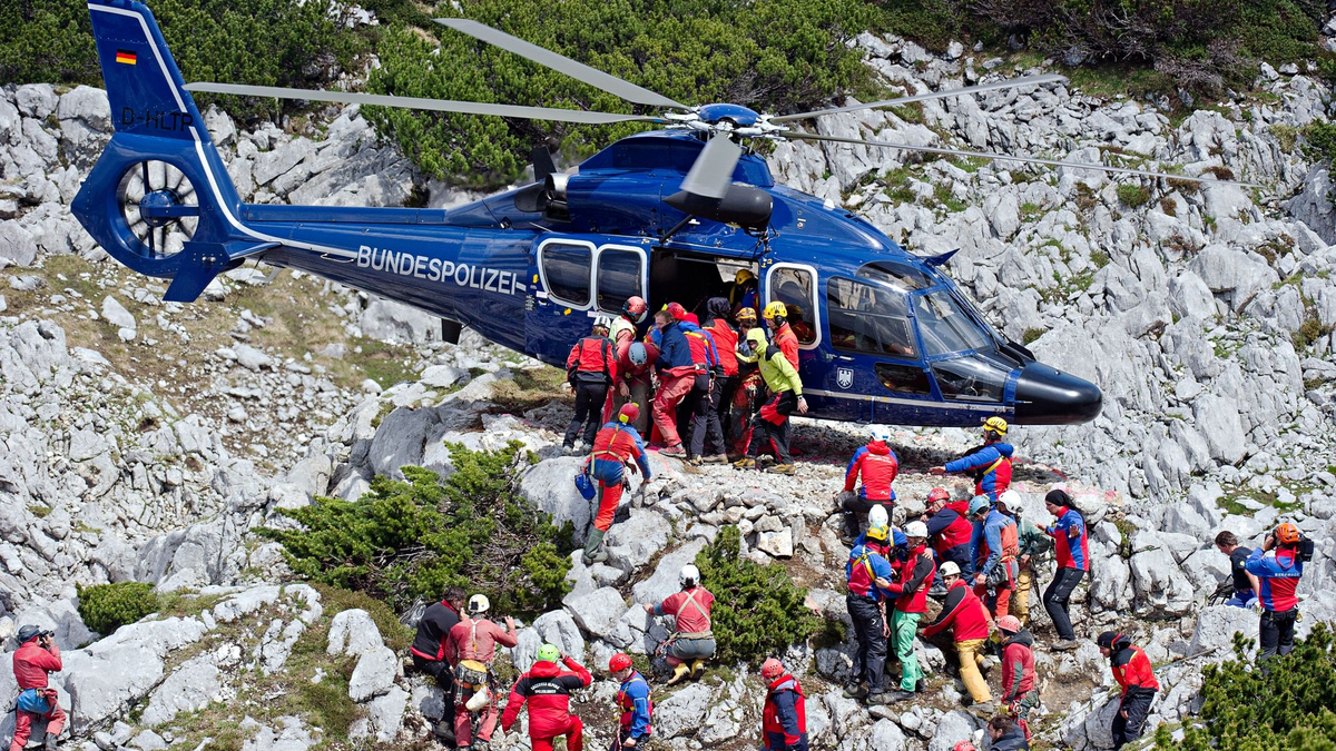 Rettungskräfte tragen am 19.06.2014 am Untersberg bei Marktschellenberg (Bayern) nahe des Einstiegs der Riesending-Schachthöhle den verletzten Höhlenforscher Johann Westhauser auf einer Trage in einen Helikopter der Bundespolizei. - Foto: Nicolas Armer/dpa