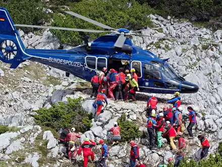 Rettungskräfte tragen am 19.06.2014 am Untersberg bei Marktschellenberg (Bayern) nahe des Einstiegs der Riesending-Schachthöhle den verletzten Höhlenforscher Johann Westhauser auf einer Trage in einen Helikopter der Bundespolizei. - Foto: Nicolas Armer/dpa