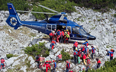 Rettungskräfte tragen am 19.06.2014 am Untersberg bei Marktschellenberg (Bayern) nahe des Einstiegs der Riesending-Schachthöhle den verletzten Höhlenforscher Johann Westhauser auf einer Trage in einen Helikopter der Bundespolizei. - Foto: Nicolas Armer/dpa