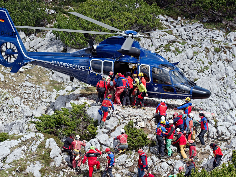 Rettungskräfte tragen am 19.06.2014 am Untersberg bei Marktschellenberg (Bayern) nahe des Einstiegs der Riesending-Schachthöhle den verletzten Höhlenforscher Johann Westhauser auf einer Trage in einen Helikopter der Bundespolizei. - Foto: Nicolas Armer/dpa
