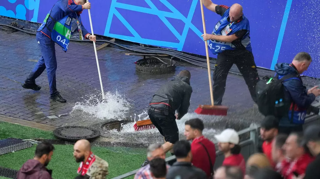 Kampf gegen die Wassermassen: Mitarbeiter sind vor dem Spiel Türkei gegen Georgien im Stadion im Einsatz. - Bild: Andreea Alexandru/AP