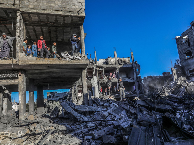 Palästinenser inspizieren die Schäden nach einem israelischen Luftangriff in der Stadt Rafah. Nach dem Kriegsrecht müssen zivile Einrichtungen bei Angriffen möglichst verschont werden. - Foto: Abed Rahim Khatib/dpa