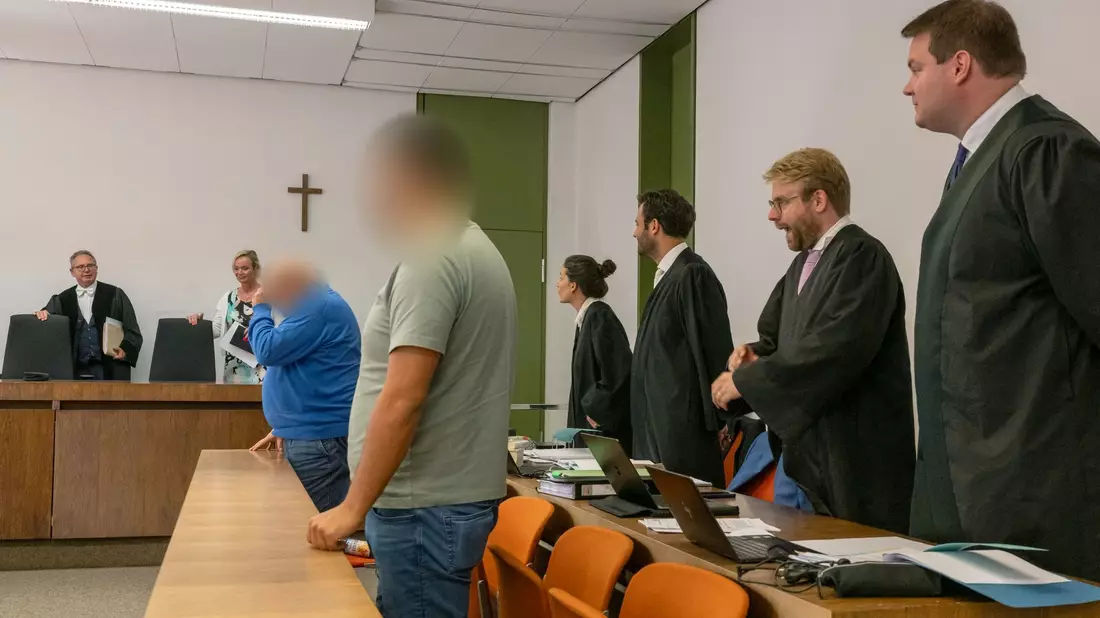 Richter Martin Hofmann (l.) sowie die beiden Angeklagten (vorne) zum Auftakt des Prozesses. - Bild: Peter Kneffel/dpa