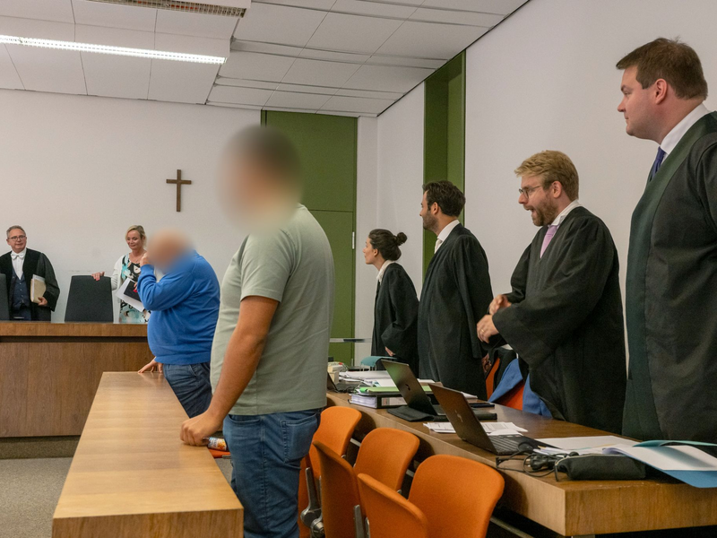 Richter Martin Hofmann (l.) sowie die beiden Angeklagten (vorne) zum Auftakt des Prozesses. - Foto: Peter Kneffel/dpa