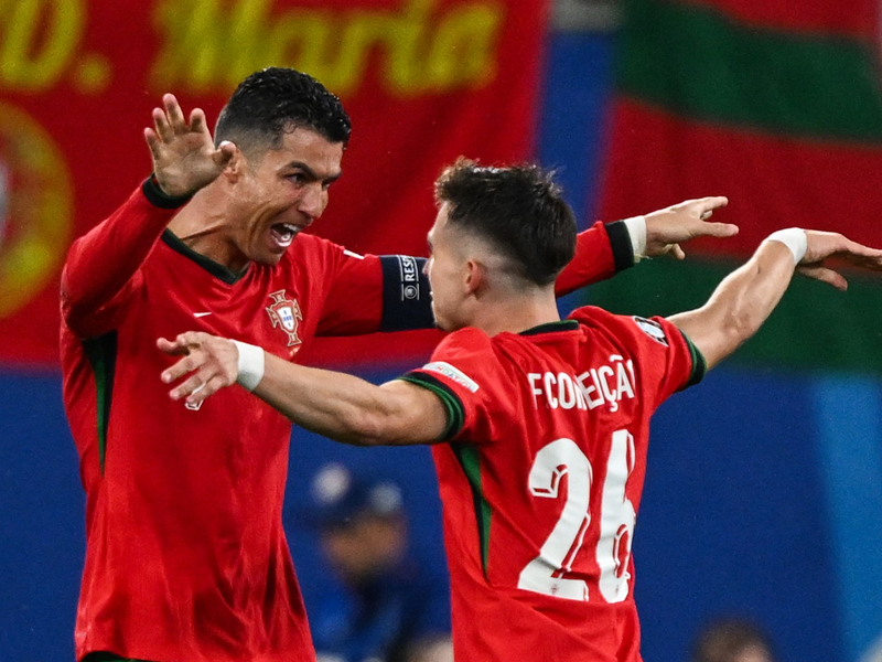Superstar Cristiano Ronaldo (l) feiert den Torschützen Francisco Conceição. - Foto: Hendrik Schmidt/dpa