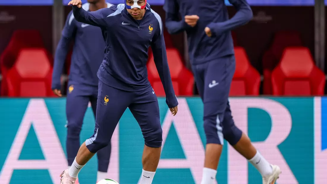 Frankreichs Superstar Kylian Mbappé muss nach seinem Nasenbeinbruch mit einer Maske trainieren. - Bild: Jan Woitas/dpa
