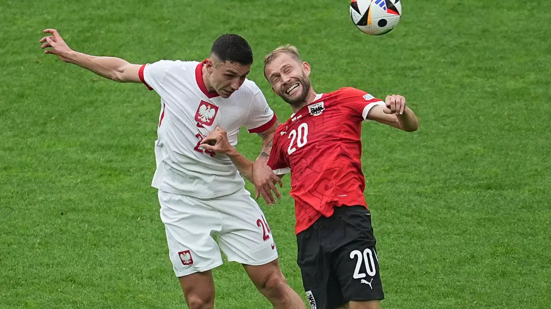 Polens Bartosz Slisz (l) im Kopfballduell mit dem Österreicher Konrad Laimer. - Bild: Michael Kappeler/dpa